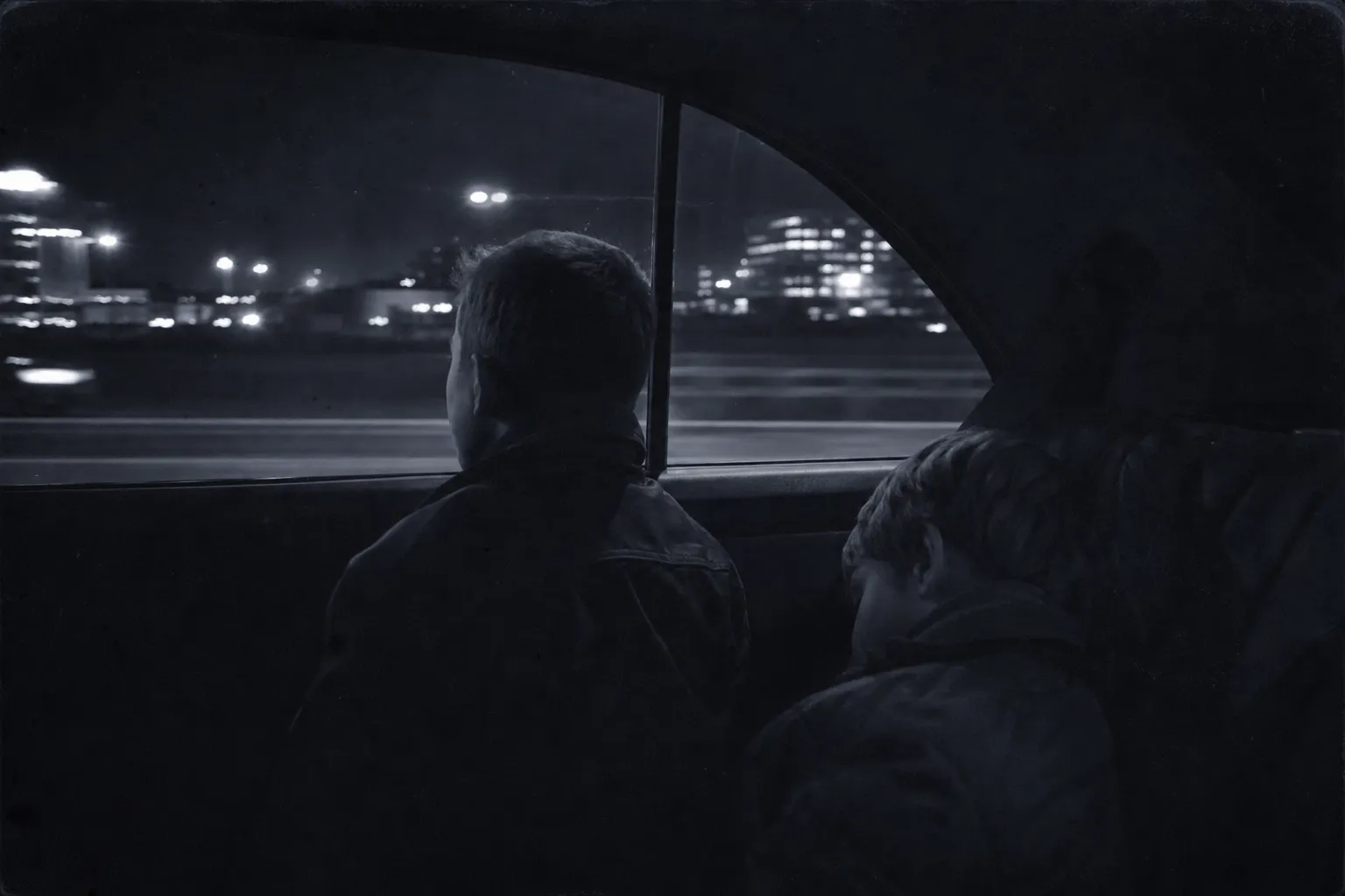 The back seat of a car on a European motorway at night in the mid-1990s: a boy of nine presses his forehead to the window, watching a strange city's lights.