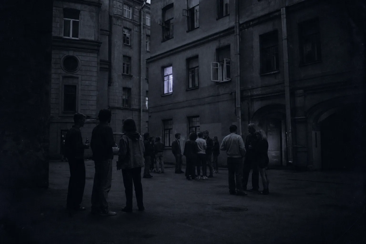 A summer evening in a Saint Petersburg courtyard in the late 1990s: a crowd of young people, mostly guys and a couple of girls, standing in groups with beer, white-night light.